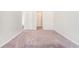 Spacious bedroom with neutral carpeting, light gray walls, and a door to the hallway at 2349 Hanover Woods Rd, Lithonia, GA 30058