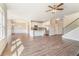 Open-concept living room with hardwood floors, dining area, kitchen with stainless steel appliances, and staircase at 2349 Hanover Woods Rd, Lithonia, GA 30058