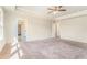 Large main bedroom with plush carpeting and a view into the bathroom and walk-in closet at 2349 Hanover Woods Rd, Lithonia, GA 30058