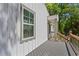 View of the side of the gray front porch with wood railing and a view of the white front door at 313 Yancy Se Dr, Marietta, GA 30067