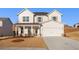 Charming two-story home features a covered front porch, a two car garage and professionally landscaped yard at 5587 Rosehall Pl, Atlanta, GA 30349