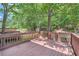 Back deck featuring wood flooring with mature trees and plants surrounding the property at 91 Davis Mill Ct, Lawrenceville, GA 30044