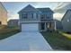 Charming two-story home featuring a gray exterior, brick accents, well-maintained lawn, and a two-car garage at 11045 Shadow Creek Ter, Hampton, GA 30228