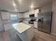 Modern kitchen equipped with stainless steel appliances, granite countertops, a central island, and ample cabinet space at 11045 Shadow Creek Ter, Hampton, GA 30228
