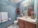Cozy bathroom featuring blue walls, white tile flooring, and a wood vanity and decorative accents at 2100 Highway 138 E E, Stockbridge, GA 30281