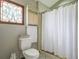 Powder room featuring decorative stained glass window and toilet with white shower curtain at 2100 Highway 138 E E, Stockbridge, GA 30281