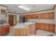 Spacious kitchen featuring wood cabinets, an island with a sink, and tile backsplash and flooring at 2100 Highway 138 E E, Stockbridge, GA 30281