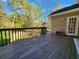 Large wooden deck with railing overlooks the backyard with a lawn and mature trees at 1225 Creek Laurel Dr, Lawrenceville, GA 30043