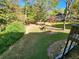 A grassy backyard with mature trees and play structure and brick walkway from the deck at 1225 Creek Laurel Dr, Lawrenceville, GA 30043