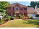 Charming two-story brick home with a well-manicured lawn and mature landscaping at 1225 Creek Laurel Dr, Lawrenceville, GA 30043