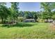 Backyard featuring an expansive yard, green grass, wooden playhouse, and mature trees surrounding the property at 3627 Groovers Lake Rd, Lithia Springs, GA 30122