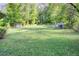 Large, grassy backyard with mature trees, offering privacy and space for outdoor activities at 3627 Groovers Lake Rd, Lithia Springs, GA 30122