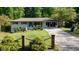 Inviting exterior showcases a ranch-style home with a well-kept lawn, complemented by brick pillars and verdant greenery at 3627 Groovers Lake Rd, Lithia Springs, GA 30122