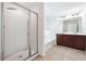 Bright bathroom featuring a glass shower, soaking tub, dual vanity with stylish light fixtures and tile floors at 4260 Hammond Bridge Dr, Suwanee, GA 30024