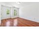 Bedroom featuring hardwood floors, two windows, and a neutral color scheme at 4260 Hammond Bridge Dr, Suwanee, GA 30024