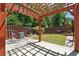 Relaxing patio space with a wooden pergola, stone pavers, and a fenced-in yard at 4260 Hammond Bridge Dr, Suwanee, GA 30024