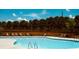 Community pool with seating, privacy fence, and trees surrounding the area at 4260 Hammond Bridge Dr, Suwanee, GA 30024
