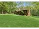 Large backyard with mature trees and a wooden deck, ideal for outdoor gatherings and relaxation at 4615 Gresham Rd, Douglasville, GA 30134
