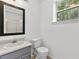 Bright bathroom with a modern sink, toilet, and a mirror; a window offers natural light and views at 4615 Gresham Rd, Douglasville, GA 30134