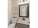Stylish half bathroom featuring a vanity with a black faucet and framed mirror at 4615 Gresham Rd, Douglasville, GA 30134