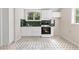 Bright kitchen features white cabinets, dark countertops, and black and white patterned tile flooring at 4615 Gresham Rd, Douglasville, GA 30134