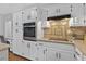 A close up of the kitchen showing the stainless appliances and tile backsplash at 4615 Gresham Rd, Douglasville, GA 30134