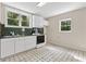 The bright kitchen features white cabinets and black/white patterned floors, creating a fresh and inviting space at 4615 Gresham Rd, Douglasville, GA 30134