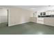 Open living area with green carpet and a partial kitchen view, offering a cozy and inviting space at 4615 Gresham Rd, Douglasville, GA 30134