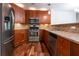 Updated kitchen features stainless steel appliances, wood cabinets, granite counters, and tiled backsplash at 476 Sherman Way, Decatur, GA 30033