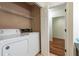 This laundry room has a washer and dryer and a door leading to another room at 476 Sherman Way, Decatur, GA 30033