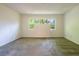 The empty living room has neutral carpeting and a large picture window overlooking a wooded area at 476 Sherman Way, Decatur, GA 30033