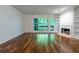 Bright living room features hardwood floors, a fireplace, built-in shelves, and a large window with natural light at 476 Sherman Way, Decatur, GA 30033