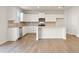 Well-lit kitchen featuring white cabinets, stainless appliances, and wood floors at 5599 Rosehall Pl, Atlanta, GA 30349
