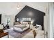 Stylish bedroom boasts a high ceiling, dark accent wall, cozy bed, and dedicated workspace for a modern lifestyle at 120 Park Bridge Ln, Roswell, GA 30075