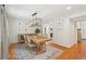 Elegant dining room with a wooden table, hardwood floors, modern lighting fixture and decorative wall art at 120 Park Bridge Ln, Roswell, GA 30075