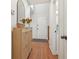 Bright entryway features hardwood floors, a wooden storage cabinet with a mirror, and a white front door at 120 Park Bridge Ln, Roswell, GA 30075