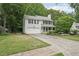 Beautiful two-story home with a garage, manicured lawn, and mature trees at 120 Park Bridge Ln, Roswell, GA 30075