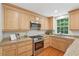 Bright kitchen featuring wooden cabinets, stainless steel appliances, and granite countertops at 120 Park Bridge Ln, Roswell, GA 30075