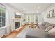 The inviting living room features hardwood floors, a gray sectional sofa, fireplace, and large windows for natural light at 120 Park Bridge Ln, Roswell, GA 30075