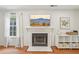 Inviting living room with a decorative fireplace, television, hardwood floors, and plenty of natural light at 120 Park Bridge Ln, Roswell, GA 30075