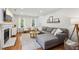 Cozy living room featuring hardwood floors, a gray sectional sofa, fireplace, and natural light streaming through the windows at 120 Park Bridge Ln, Roswell, GA 30075