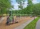 Modern playground equipment including climbing structures, a slide, and swings, all on a wood chip base at 120 Park Bridge Ln, Roswell, GA 30075