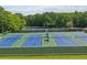 Aerial view of tennis courts surrounded by mature trees, and green fence with blue tennis court for sport and recreation at 120 Park Bridge Ln, Roswell, GA 30075