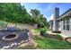 Inviting backyard with a fire pit, swing bench, shed, and lush landscaping, perfect for outdoor relaxation and entertainment at 20 Spruce Ne St, White, GA 30184