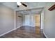 Finished basement space featuring wood floors, neutral walls, a ceiling fan, and access to another room at 20 Spruce Ne St, White, GA 30184