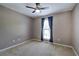 Bedroom with tan walls, carpet, ceiling fan, and a window with dark blue curtains at 20 Spruce Ne St, White, GA 30184