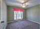 Carpeted bedroom featuring a ceiling fan and window with blinds and decorative valance at 20 Spruce Ne St, White, GA 30184