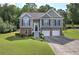 Charming two-story home featuring a stone facade, gray siding, manicured lawn, and a two-car garage at 20 Spruce Ne St, White, GA 30184
