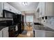 Modern kitchen features white cabinets, black appliances, tile backsplash, and stainless steel sink at 20 Spruce Ne St, White, GA 30184