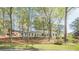 Lovely home nestled among mature trees, with a white exterior and well-manicured lawn at 2729 Ridge Valley Nw Rd, Atlanta, GA 30327